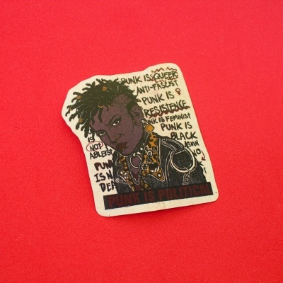 Adesivo com arte punk e texto político sobre fundo vermelho.