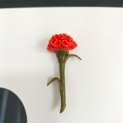 Miniatura de flor artificial vermelha com caule verde sobre fundo branco