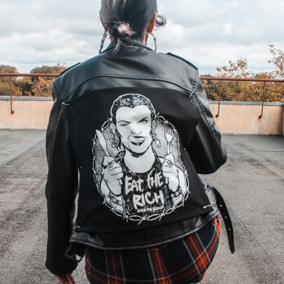 Casaco de couro preto com estampa branca na parte de trás, pessoa de costas num terraço com árvores no fundo.