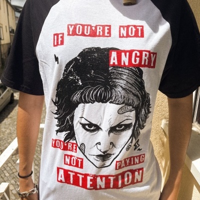 T-shirt preta e branca com estampa de rosto e texto em vermelho e branco.