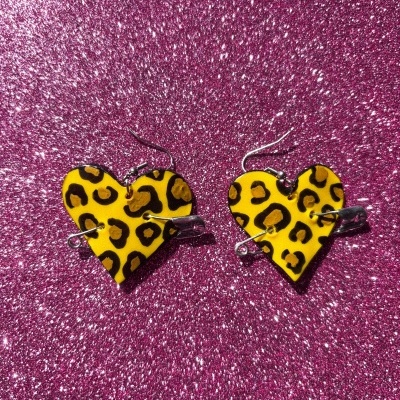 Brincos coração amarelo padrão leopardo em fundo brilhante rosa púrpura