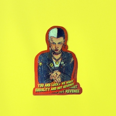 Adesivo de pessoa com cabelo metade branco metade preto e casaco de couro azul com texto sobre igualdade