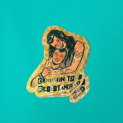 Adesivo ilustrado de duas pessoas abraçadas com texto COMMUNITY IS RESISTANCE sobre fundo azul-turquesa