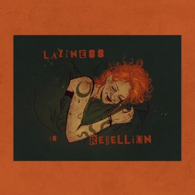 Pessoa ruiva com tatuagens a descansar e texto LAZINESS IS REBELLION