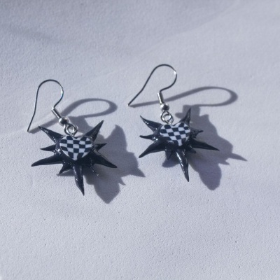 Brincos em forma de estrelas pretas com coração xadrez branco e preto