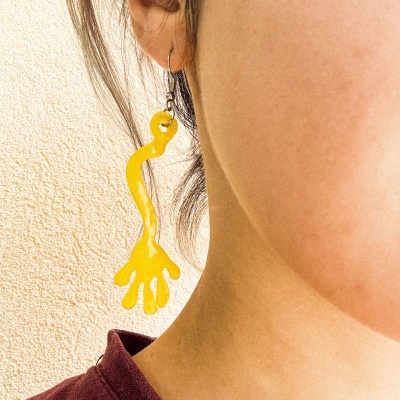Brinco pendente amarelo em orelha feminina