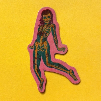 Adesivo de figura feminina com esqueleto em fundo rosa sobre parede amarela