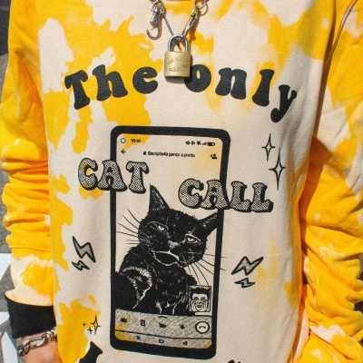 Sweatshirt tie-dye amarela e creme com estampa de gato e texto