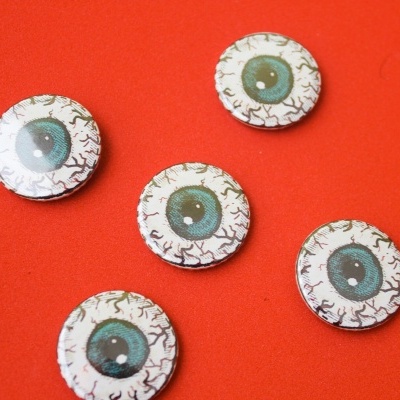 Botões redondos com padrão de olhos azuis sobre fundo vermelho