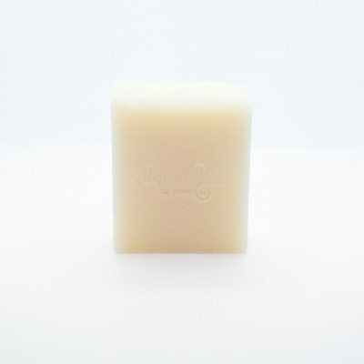 Barra de sabão bege clara com relevo em fundo branco