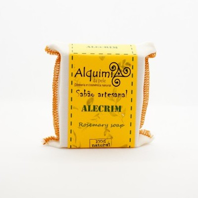 Sabonete artesanal com etiqueta amarela e embalagem de tecido branco com pontos laranja.