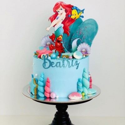 Bolo azul tema Pequena Sereia com figuras e decoração marinha, texto Beatrix