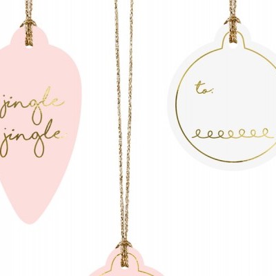 Três etiquetas de papel para presente em rosa claro e branco com texto dourado penduradas