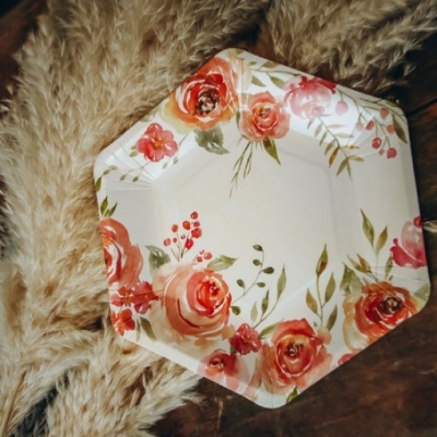 Prato plástico octogonal com estampa floral colorida sobre tecido felpudo e madeira