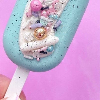 Gelado em pau azul claro com decoração colorida sobre fundo rosa