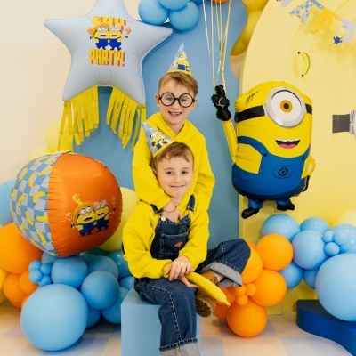 Crianças com chapéus dos Minions e balões coloridos de festa