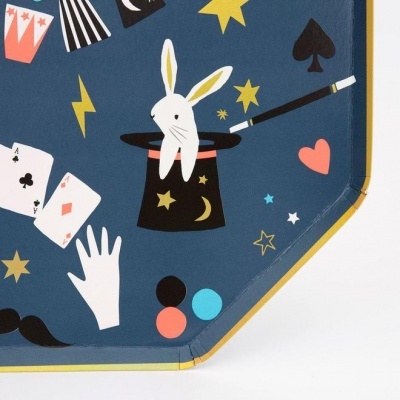 Pano azul com ilustrações de elementos mágicos como chapéu com coelho, cartas e varinha mágica.