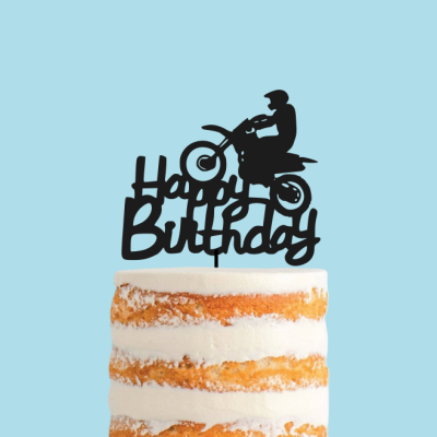 Topo de bolo preto com frase 'Happy Birthday' e figura de mota em bolo de camadas