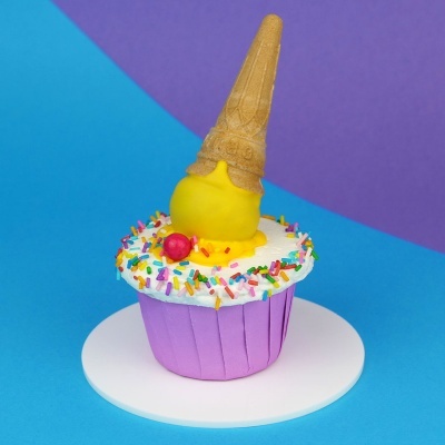 Bolo decorado com cone de gelado amarelo e granulados coloridos