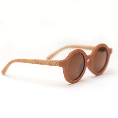 Óculos de sol redondos castanhos com hastes bege texturizadas em fundo branco
