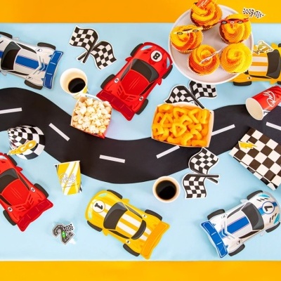 Mesa de festa decorada com tema de corridas, com carros, bandeiras, cupcakes, pipocas e snacks.