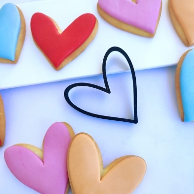 Biscoitos em forma de coração com glacê colorido e cortador de biscoitos