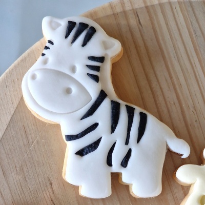 Biscoito decorado em forma de zebra com glacê branco e detalhes pretos