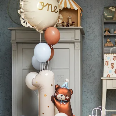 Balões decorativos para festa infantil com tema de 1 ano em ambiente interior com móveis cinzentos