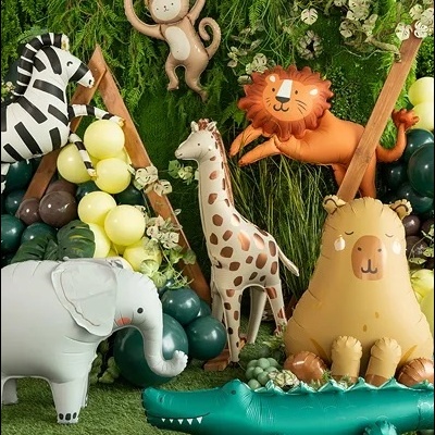 Balões insufláveis de animais da selva numa decoração com folhagens e balões coloridos