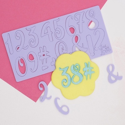 Molde silicone lilás com números e símbolos e recortes aplicados em amarelo e azul