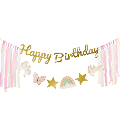 Guirlanda de aniversário com letras douradas, fitas rosa e bege, estrelas douradas, arco-íris, borboleta e unicórnios brancos