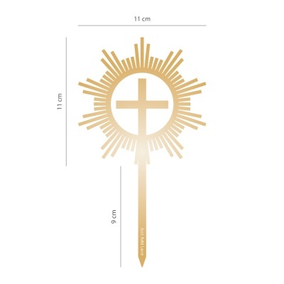 Objeto dourado decorativo em forma de sol com cruz central e haste vertical, fundo branco