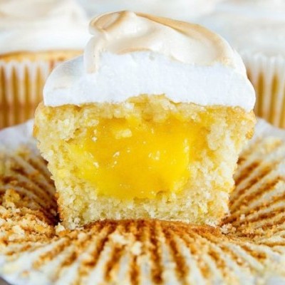 Muffin partido com recheio amarelo e cobertura branca