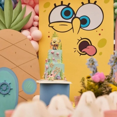 Bolo decorado de três andares com tema marinho e decoração do Bob Esponja em fundo amarelo