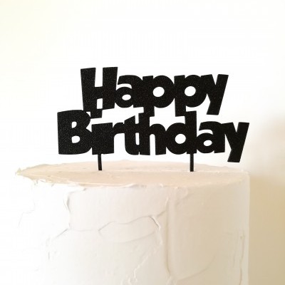 Bolo branco com cobertura e enfeite de bolo preto glitter 'Happy Birthday'