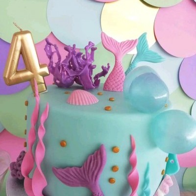 Bolo de aniversário estilo marinho com vela número 4 e decoração em tons pastel