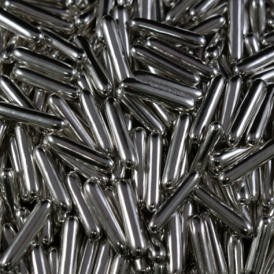 Cápsulas metálicas prateadas brilhantes sobre um fundo indistinto