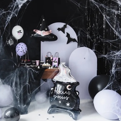Decoração de Halloween com balões, chapéu de bruxa, morcegos, teias de aranha e caldeirão com texto hocus pocus.