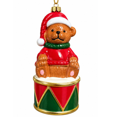 Enfeite natalício em forma de urso com chapéu de Pai Natal sentado num tambor colorido
