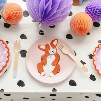 Três pratos de papel com desenhos caninos e bolas de papel coloridas ao fundo