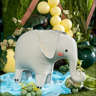 Elefante insuflável cinza claro numa decoração com balões e folhas verdes