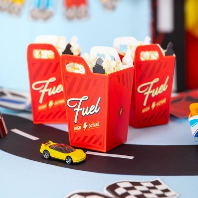 Caixas vermelhas de papel com pipoca e texto Fuel HIGH OCTANE sobre superfície azul clara
