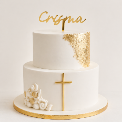 Bolo branco de duas camadas com detalhes dourados, conchas e cruz, e topper com a palavra Crisma