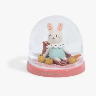 Globo de neve com figura de coelho em roupa azul e base rosa Moulin Roty