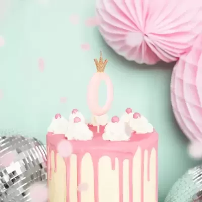 Bolo de aniversário cor-de-rosa e branco com vela decorativa e decoração de papel e bolas de espelho