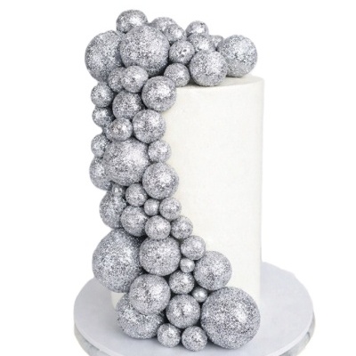 Bolo branco com decoração de bolas prateadas brilhantes