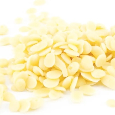 Flocos de cera amarela clara sobre fundo branco