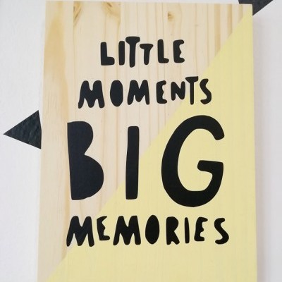 Painel decorativo de madeira com texto 'LITTLE MOMENTS BIG MEMORIES'