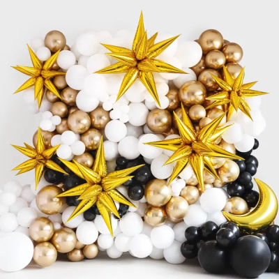 Decoração festiva com balões brancos, dourados e pretos, incluindo estrelas e lua de balão dourada