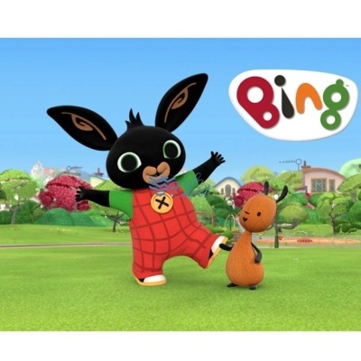 Coelho preto animado com macacão vermelho e cão castanho num campo verde com a palavra Bing